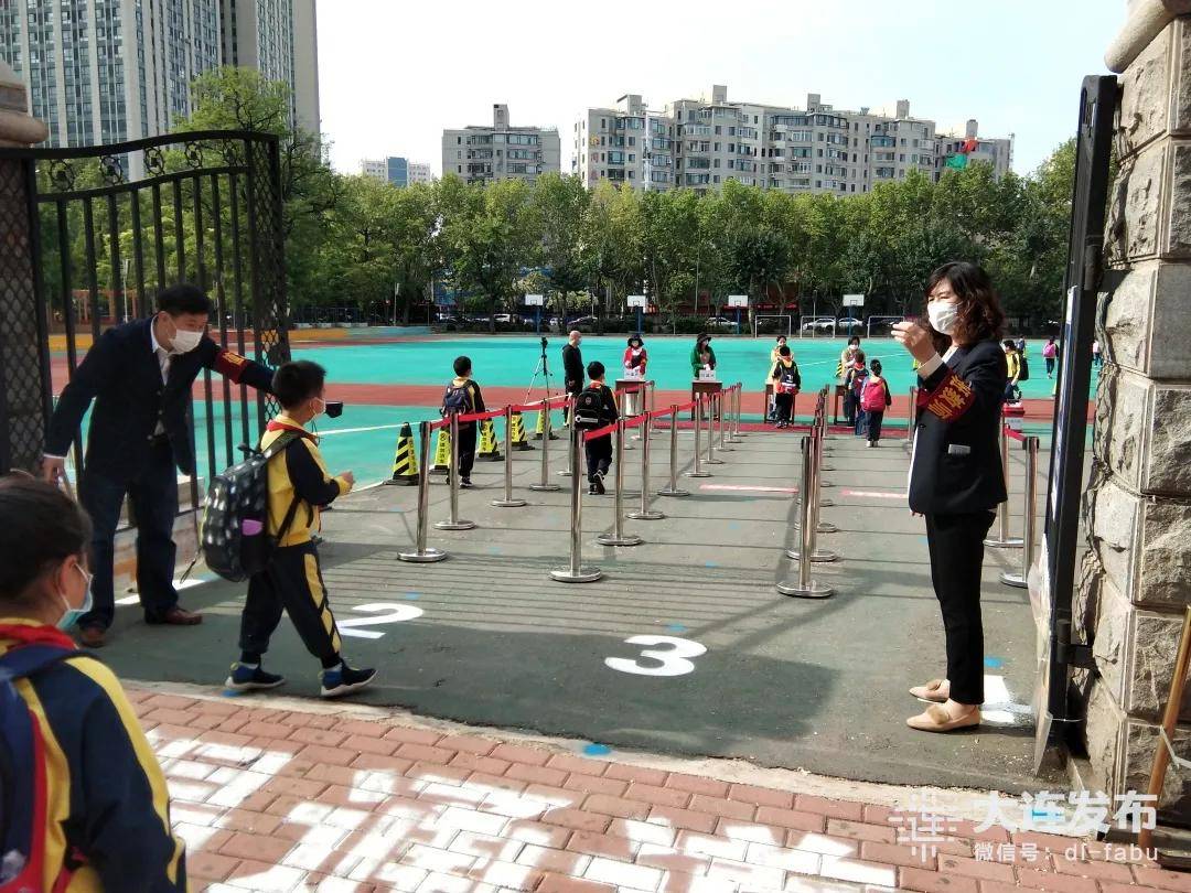 在沙河口区格致学校,学生们经过测温后,有序进入教学楼.