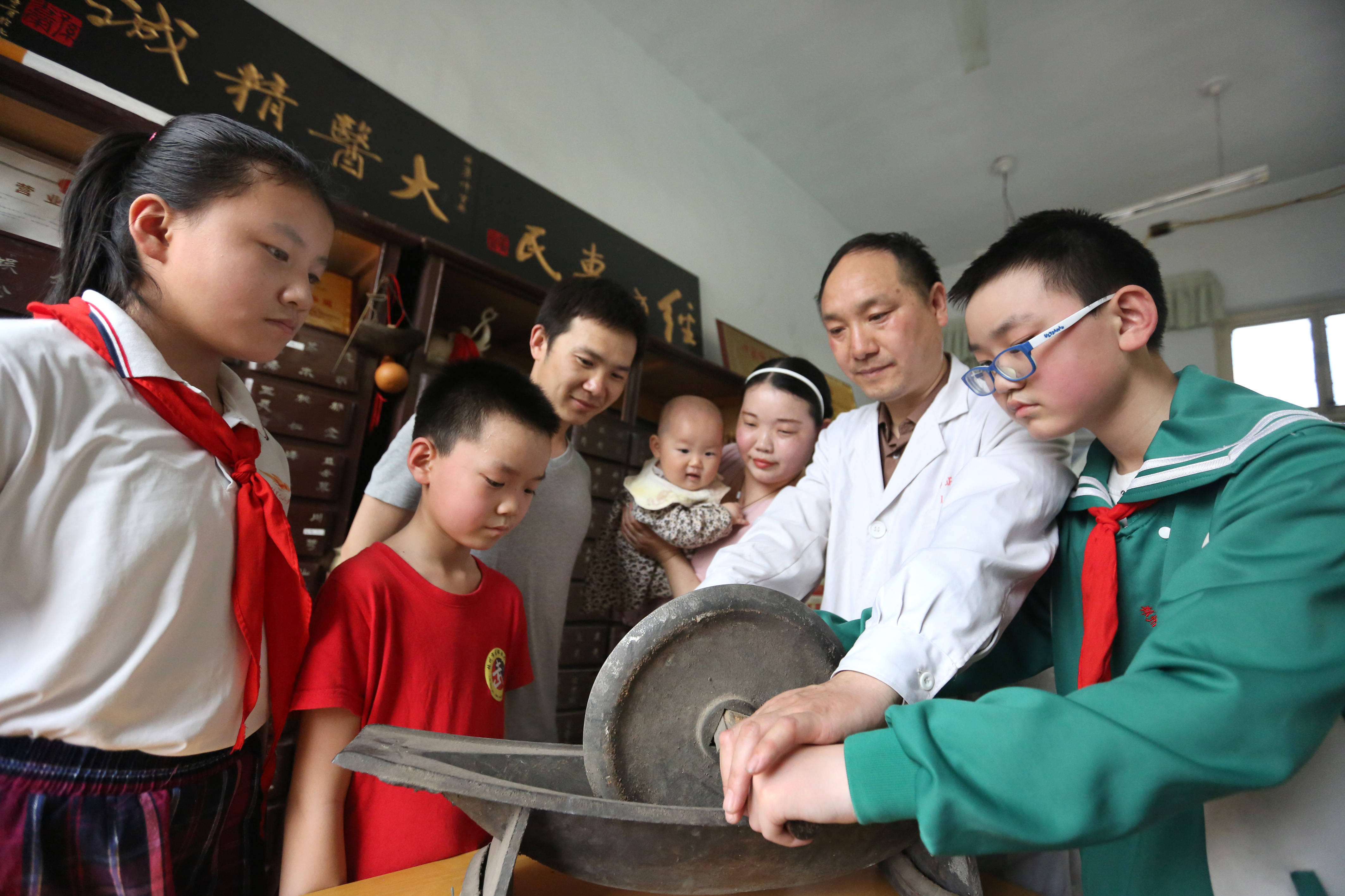 "郭氏正骨"第七代传人郭勇峰正在教授儿子郭昱均(右)如何碾制中药散剂