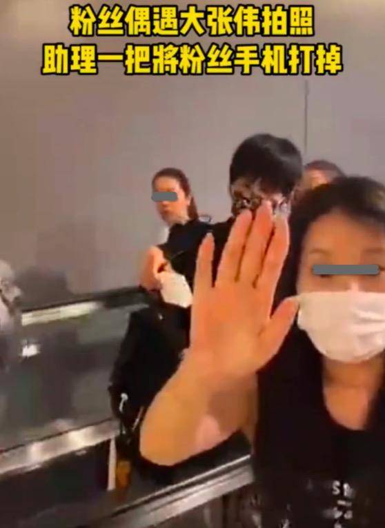 大张伟机场被跟拍，随行助理一巴掌打掉对方手