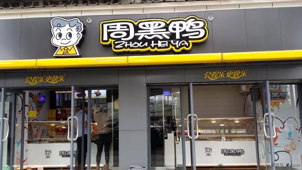 在其开设的熟食卤制品店的店铺招牌,购物袋上,使用"周黑鸭zhou hei ya