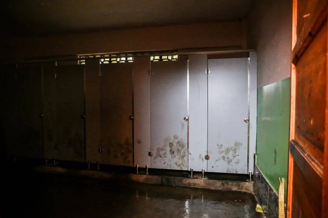 灯光昏黄闪烁,厕所墙面布满脚印,龙泉学校多年来一直使用传统旱厕