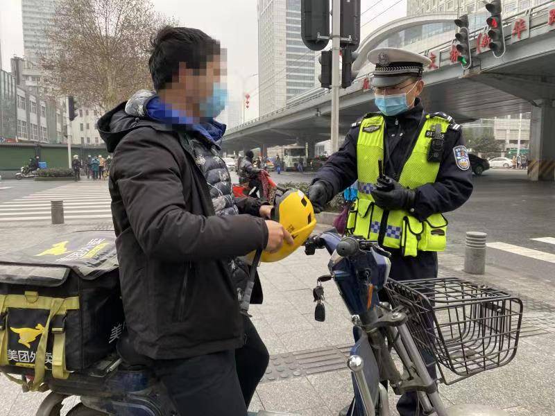 天雨路滑戴好头盔江汉交警强化电动自行车管理力度