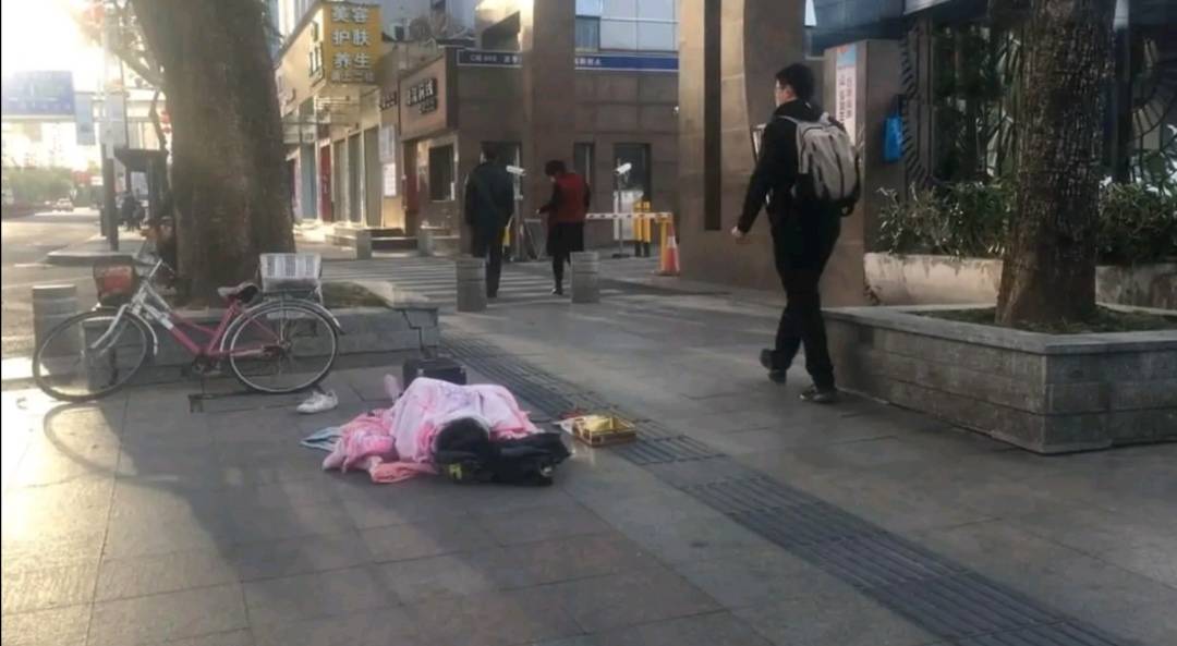 独腿女孩流浪在深圳街头,盖着粉色毛毯,旁边铁盒只有5