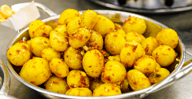 巴东炕土豆巴东炕土豆可谓是人见人爱的街头美食:炸至金黄的土豆,外皮