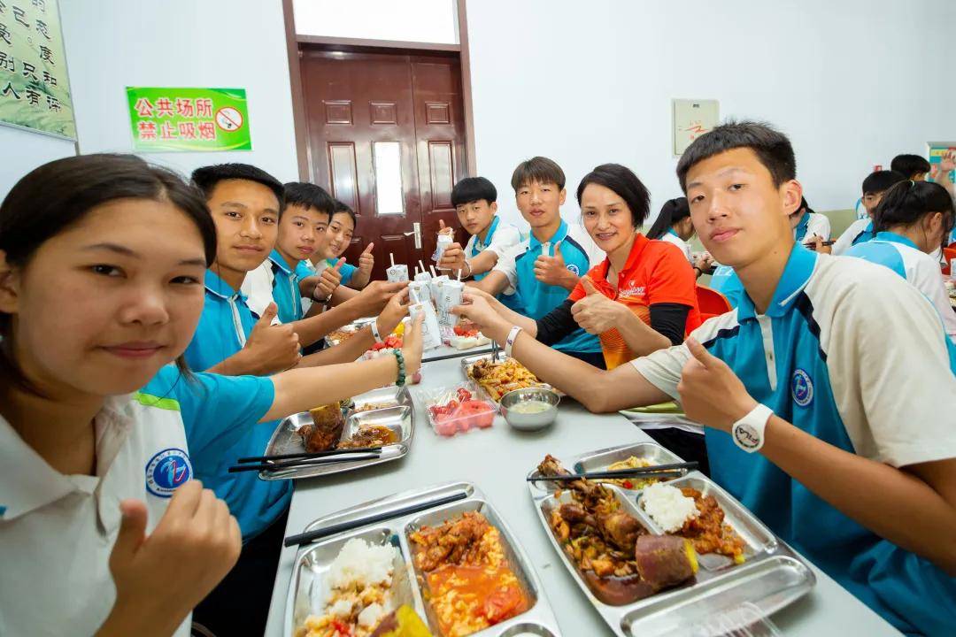 奥运冠军们和小运动员在学校食堂共享午餐,交流在训练中出现的疑惑.