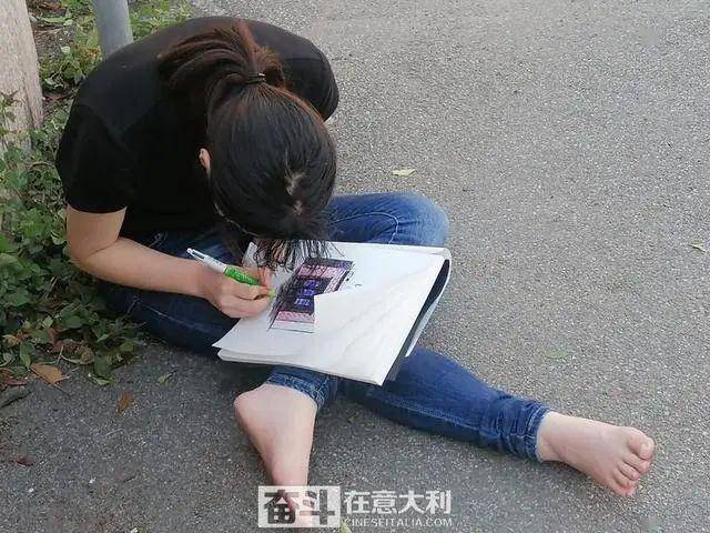 瓦雷泽20岁中国女生赤脚街头画画一言不发举止怪异