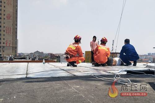 消防员一个箭步 抱住楼顶轻生女