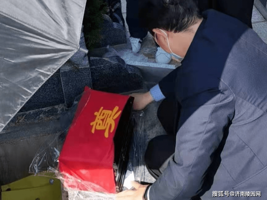 四,请灵骨入土  将由家属抱着的骨灰盒进行最后的整理,轻轻的放置在
