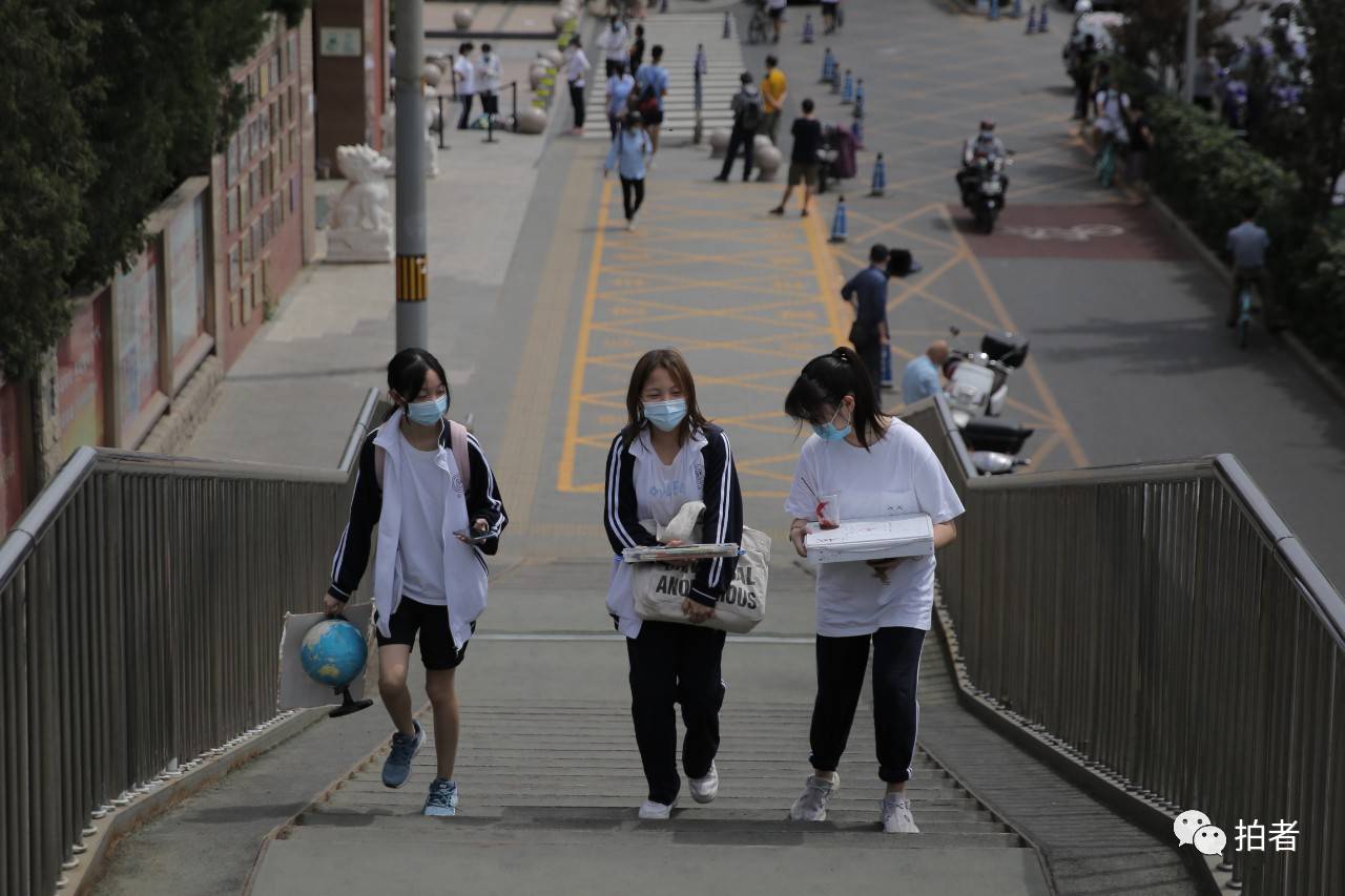 6月17日,北京市八一学校门口,一名学生收拾书包离开校园.