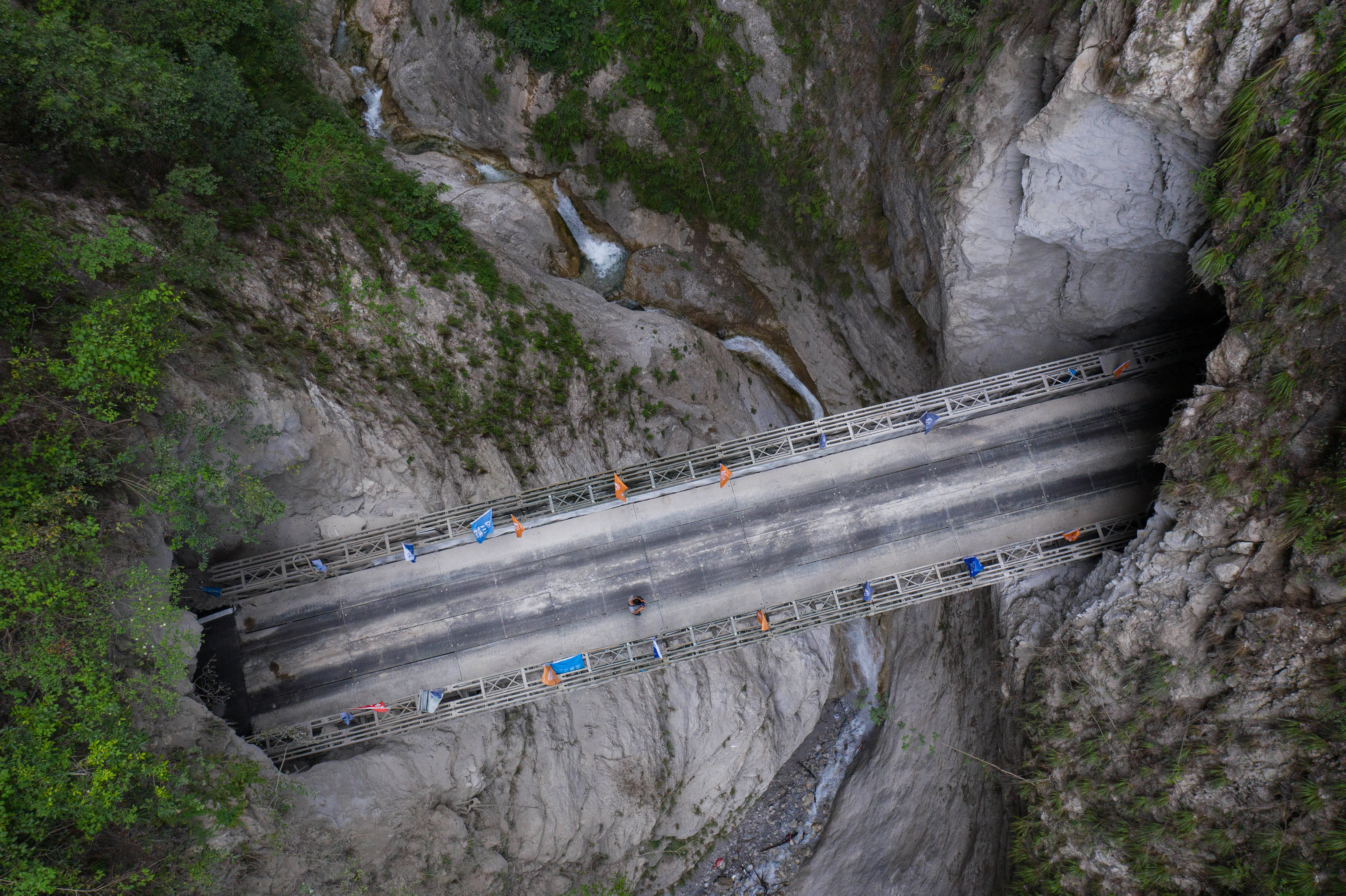 俯瞰阿布洛哈村通村公路2,3号隧道之间的钢桥(6月29日摄,无人机照片.