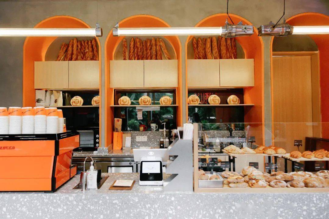 室内四个橙色拱门设计,让整家店更活泼起来,空间不大,所有的面包都