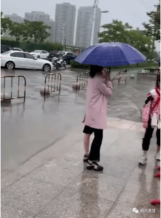 一场大雨绍兴某小学门口发大水了家长背着孩子在蹚水全身湿透