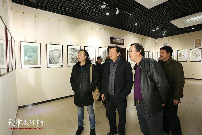 尹玉辉,杨建军,马春立在画展现场观看作品.