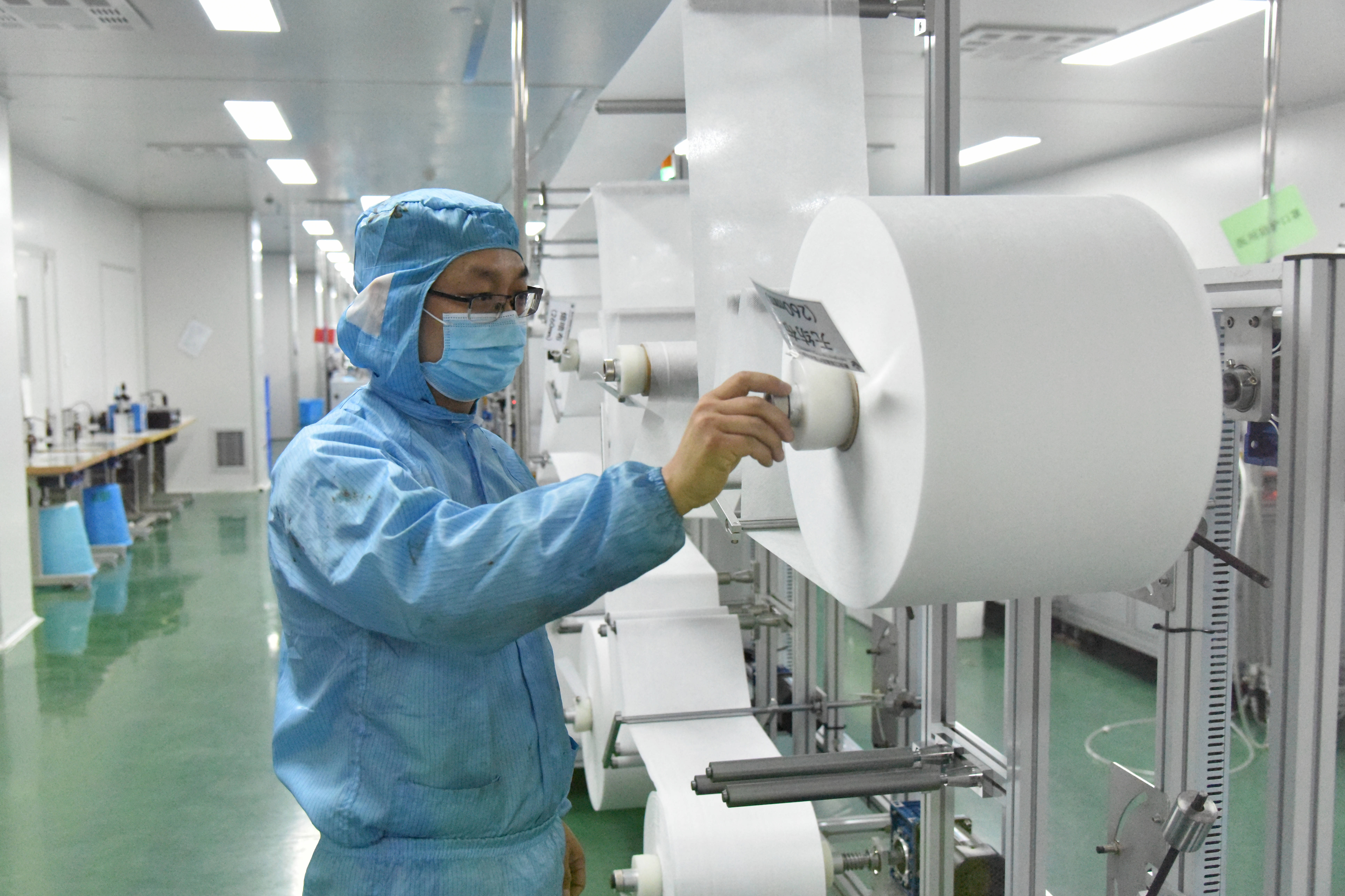 1月22日,哈尔滨市一家防疫物资生产企业工人在调试口罩生产线.