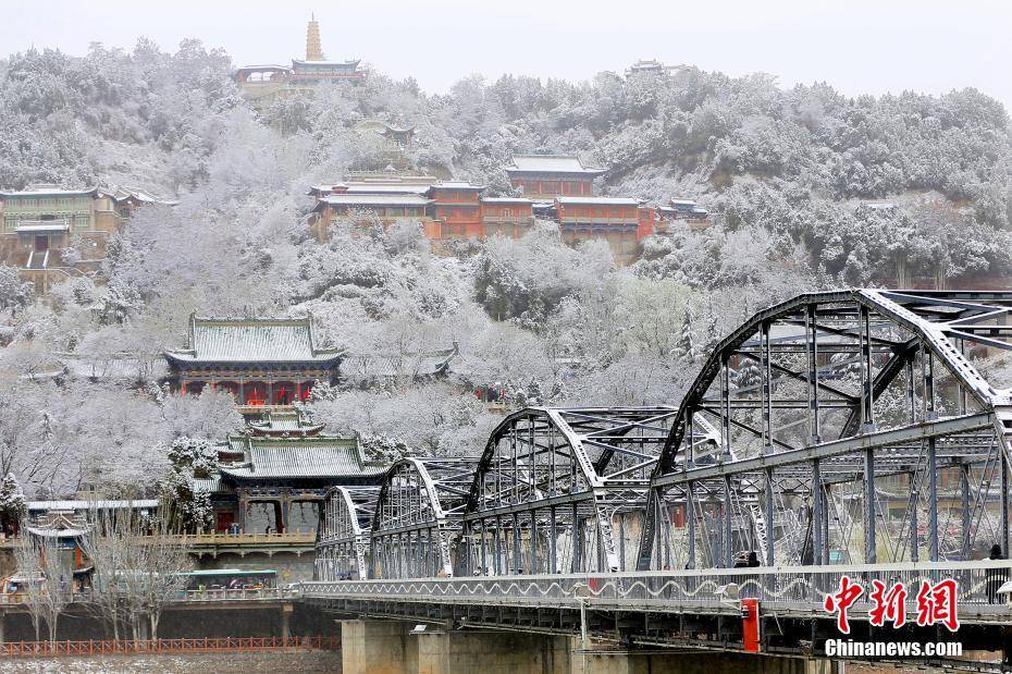 3月19日,遭遇连日沙尘天气的兰州迎来了一场春雪.图为兰州中山桥雪景.