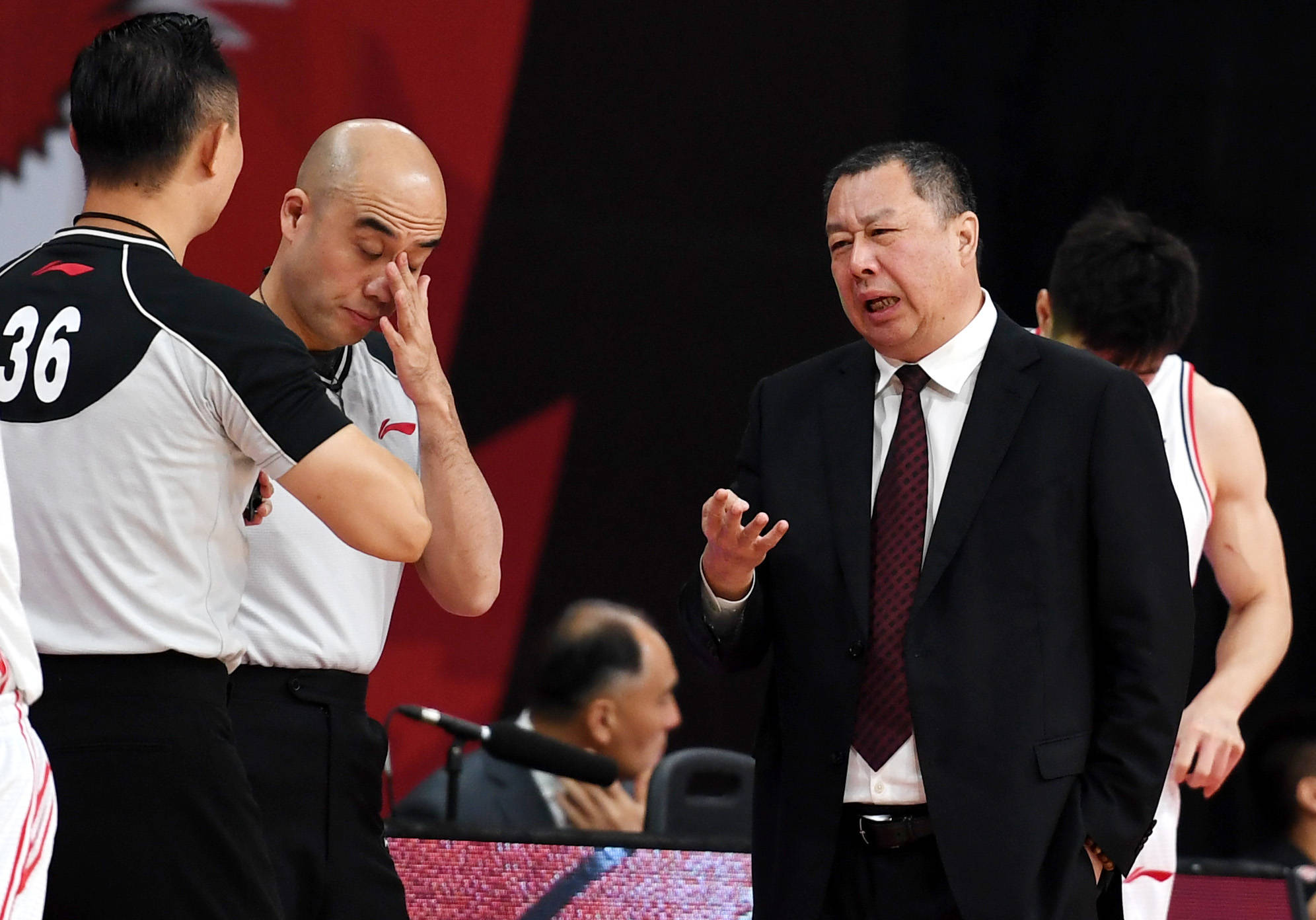 4月13日,青岛每日优鲜队主教练吴庆龙(右二)与裁判员交流.