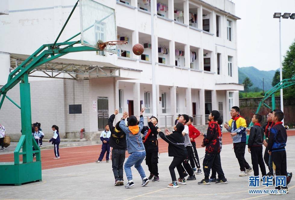 图为午餐后,鹤峰县太平镇贺龙希望小学的学生们在操场打篮球.