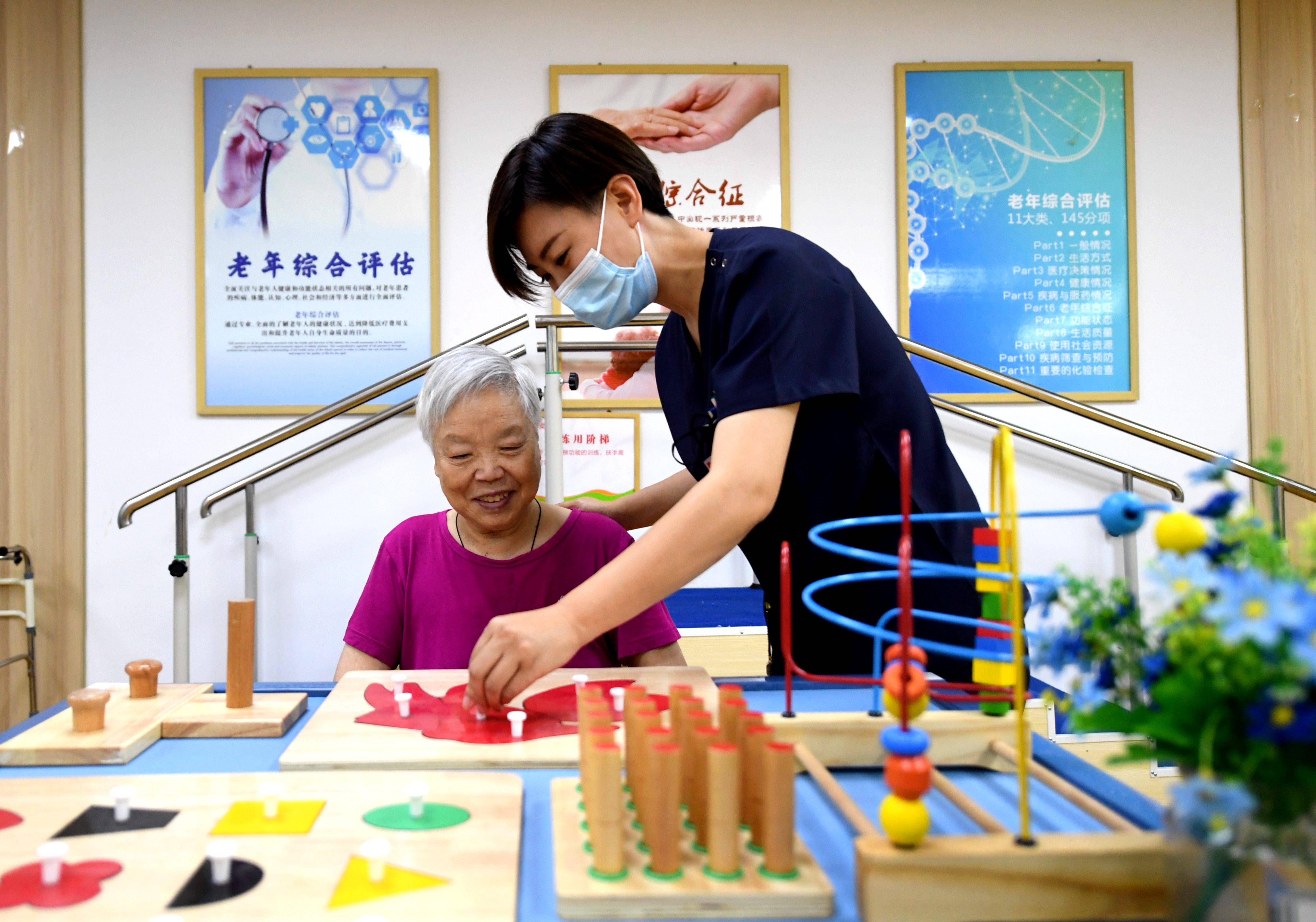 6月2日,在石家庄桥西区振头街道普爱养老照护中心,照护人员帮助老人做