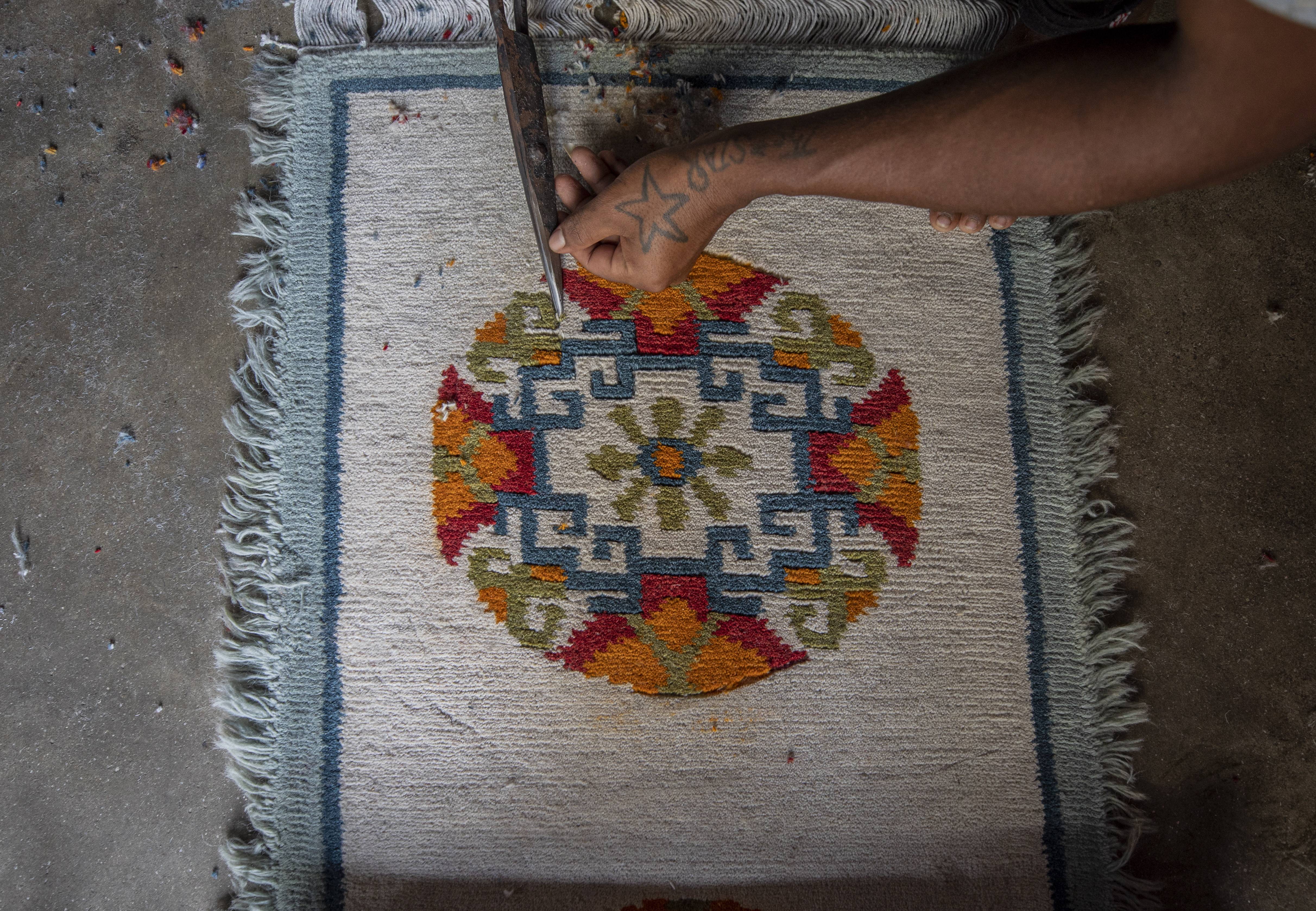 7月30日,在尼泊尔首都加德满都的一家手工地毯厂,一名工人在制作地毯.