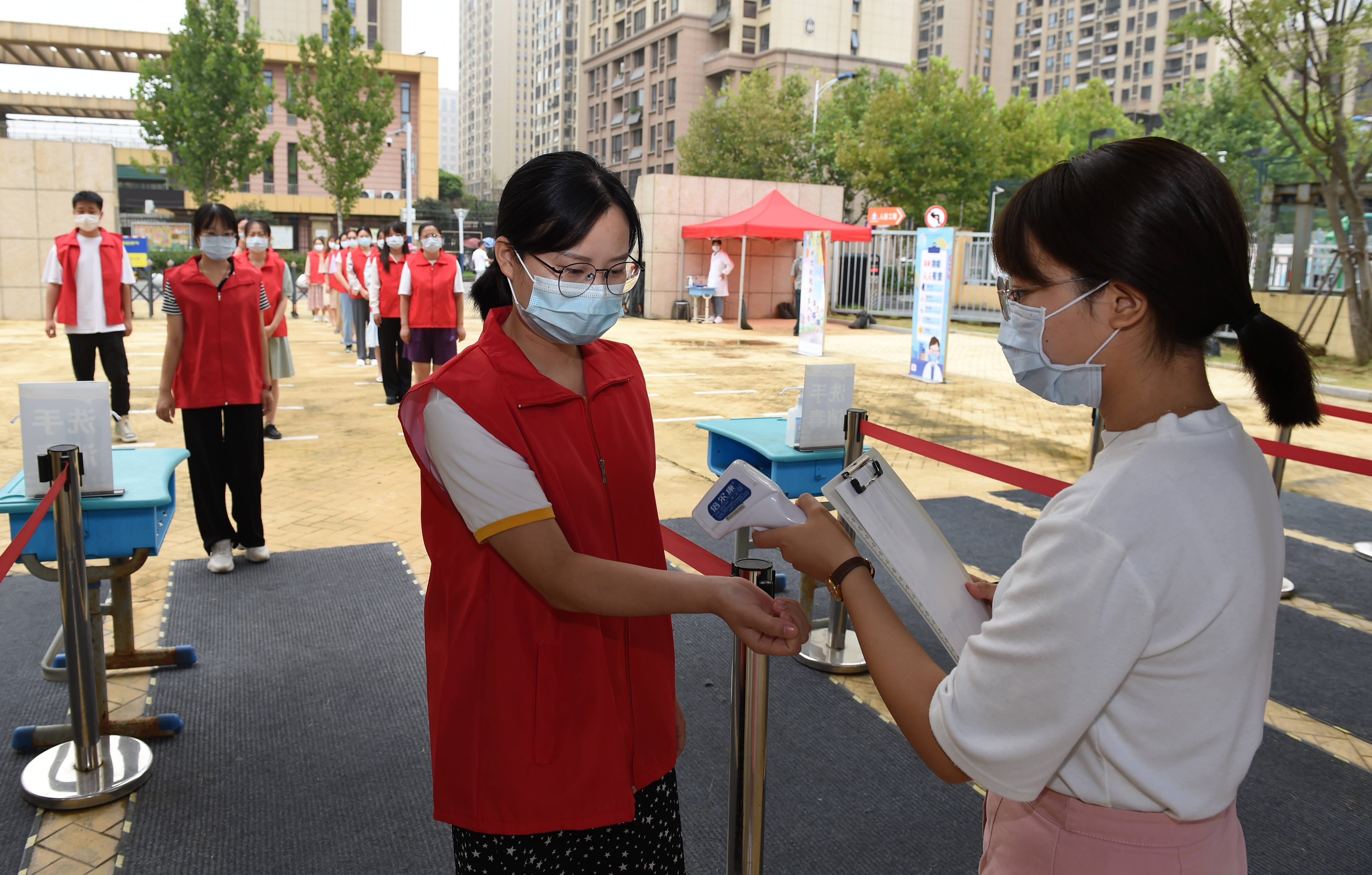 日,合肥市一六八玫瑰园学校东校区教师在演练中模拟学生排队入校测温