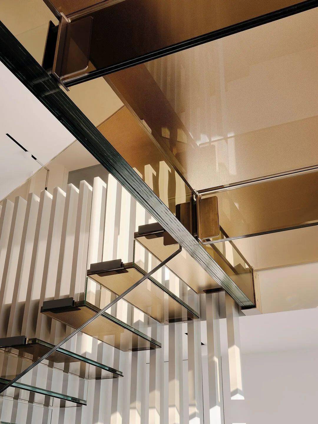 棕色玻璃的楼梯和二层连桥,不仅使得入口空间更加通透,而且也增加了
