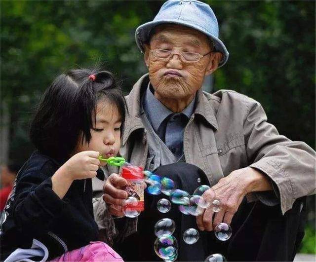 原创老人有多宠孩子?孙女太阳下玩耍,爷爷寸步不离,手上的伞过分了
