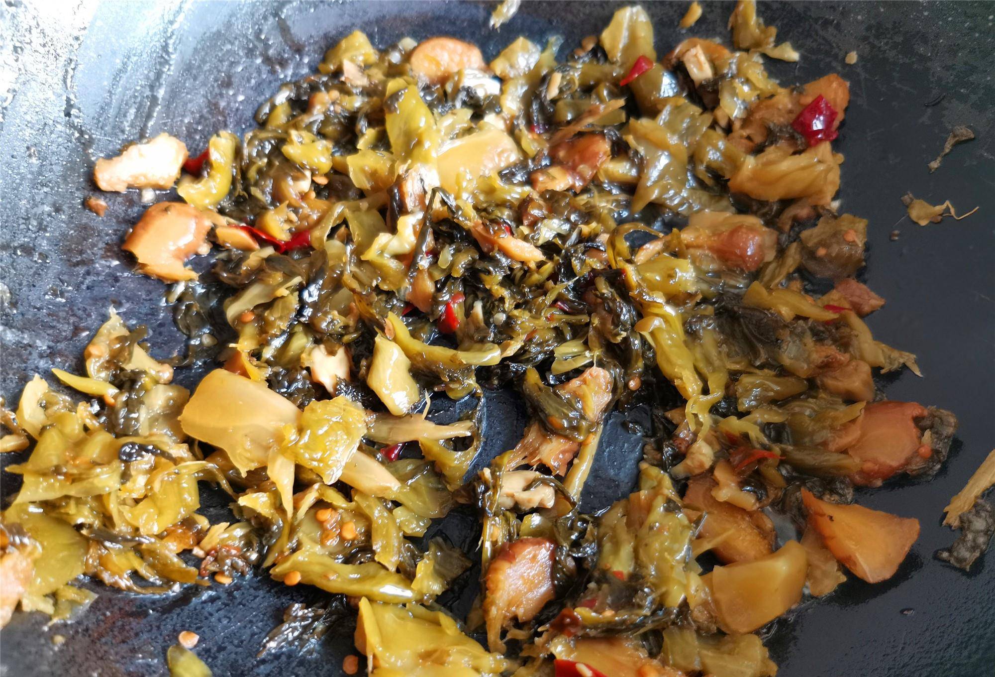 5.锅内加入油烧热,下入酸菜包中的酸菜翻炒,将酸菜炒出酸香味.