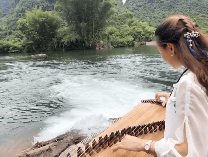 遇山乡舍在桂林阳朔遇龙河边弹古筝意境美