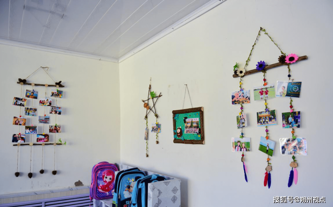 松果做成墙面装饰,上面挂着记录学生生活瞬间的照片;把各种废弃纸盒