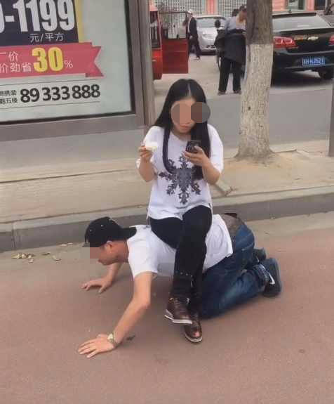 男子当凳让女友坐傻傻的看着女友接下来女友的动作让人尴尬