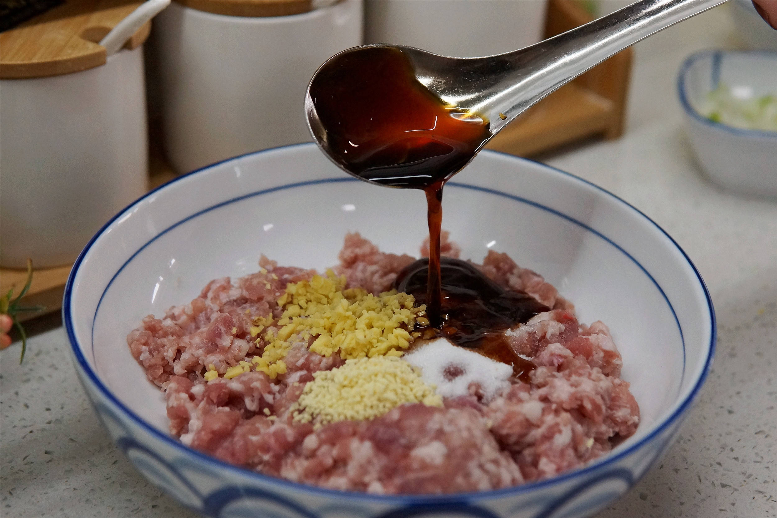第二步:肉馅中加入适量的姜末,2勺生抽,1勺老抽,半勺十三香,少量料酒