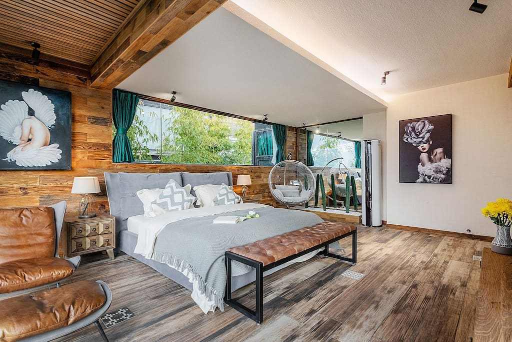 原创民宿房间是木头盒子设计,大床右侧有整面墙壁的玻璃落地窗