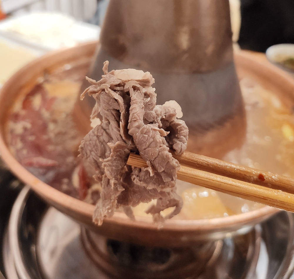 在铜火锅里涮潮汕牛肉,只需十几秒,这感觉可真妙