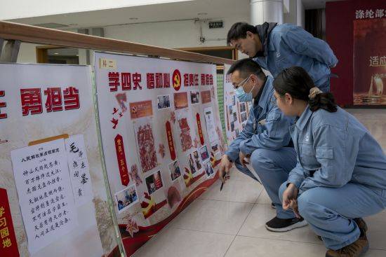 担责任,勇担当"展板上展示特色活动和员工学"四史"书法,剪纸等作品