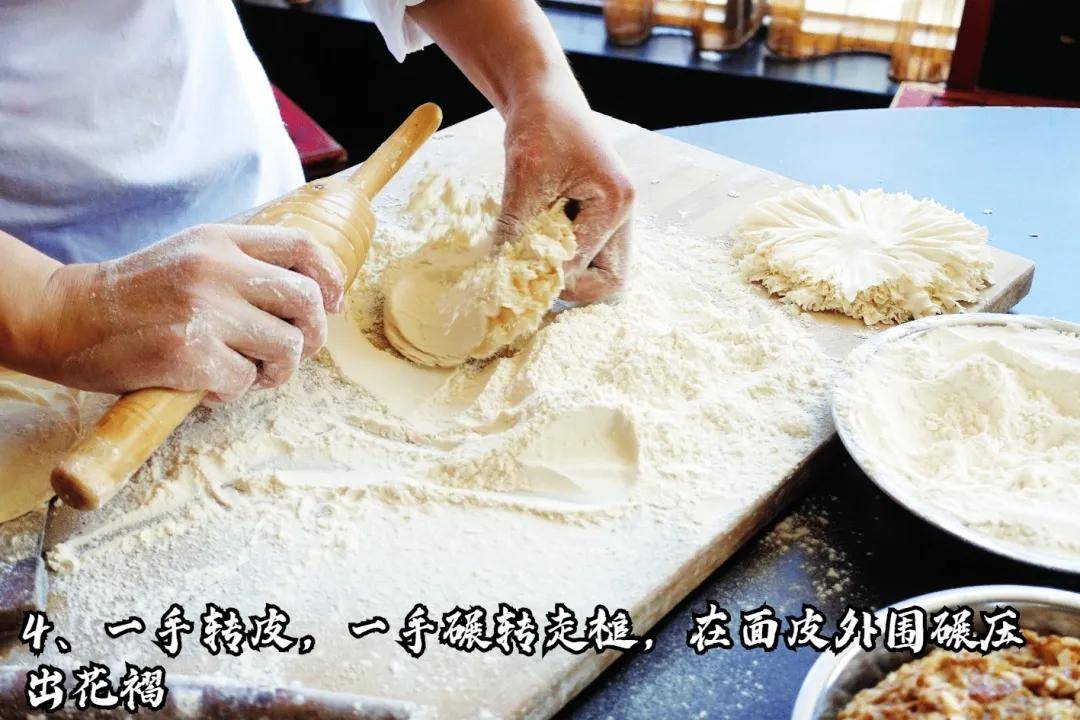 擀好的皮包上馅料,然后利用馅的黏性捏成顶部收口的雏菊状,烧麦就包好