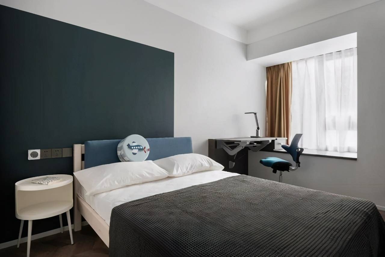 男孩子的房间里以蓝色为主题色,进门处的收纳柜和床侧的书柜连成整体