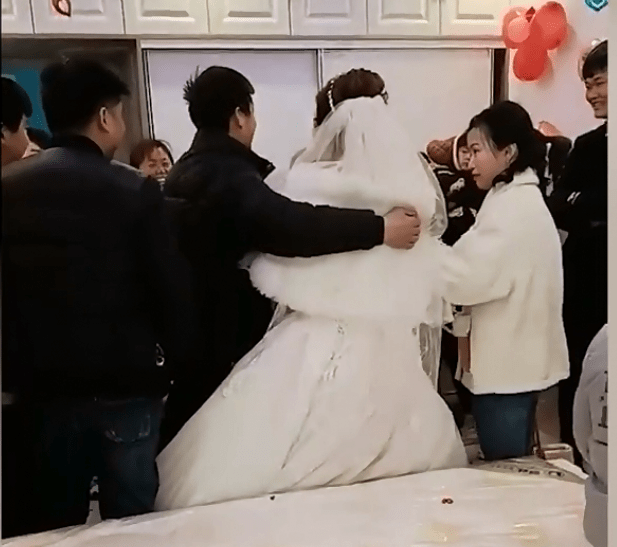 安徽阜阳"婚闹"现场,男亲友将新娘抱上床压住,新郎反应不大