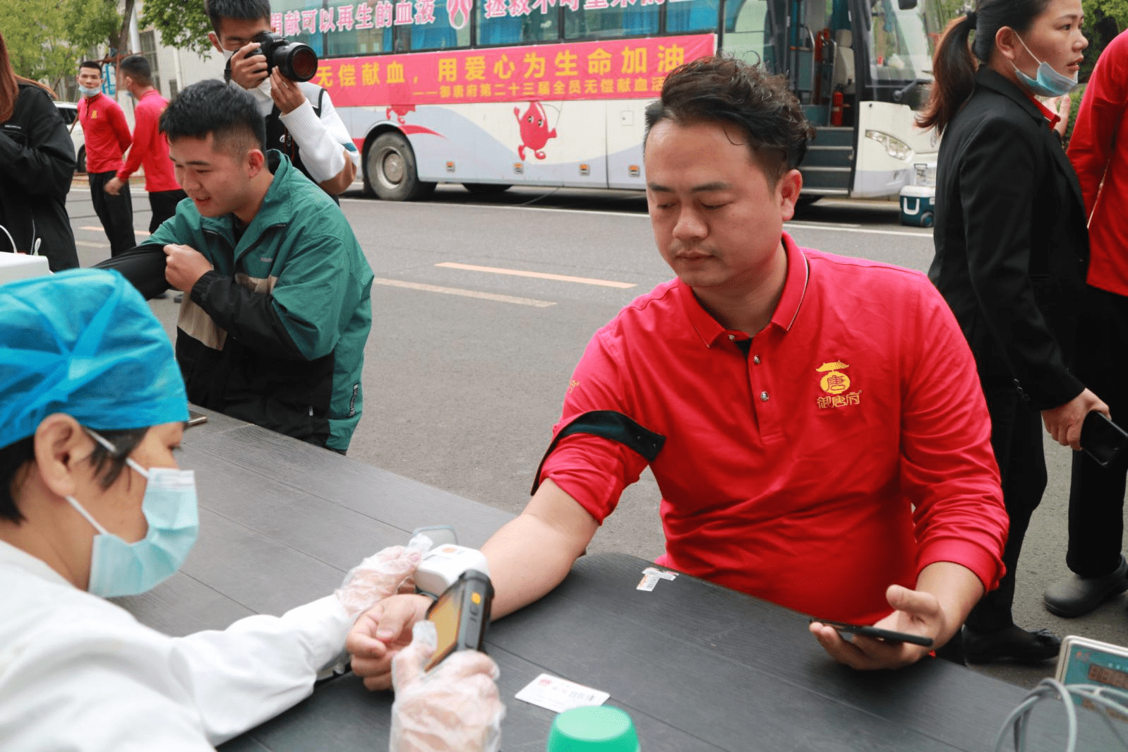 员工与市中心血站站长李殿明合影留念)御唐府"献血员工代表"徐艳芬说