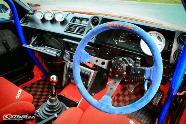 图:前排驾驶席保留绝大部分内饰,而更换赛车方向盘,这是标准的街车