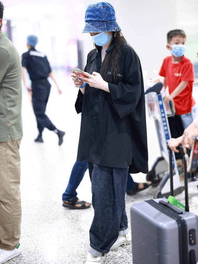 金靖身穿黑色衬衫搭配深蓝色牛仔裤休闲随性