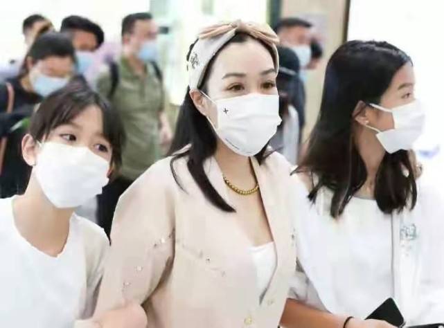 睡袍|钟丽缇机场造型收敛不少！身材丰满穿超短裤，硬穿白丝袜却有点土