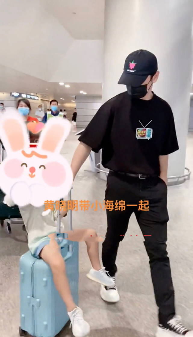 黄晓明现身机场，拉着坐在行李箱的儿子，一脸宠溺