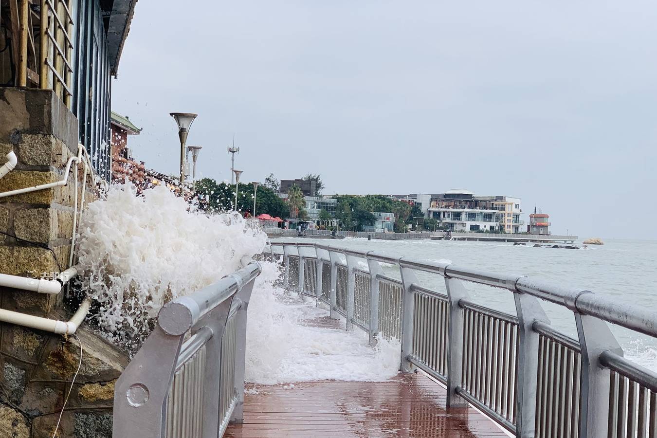 厦门版“小钱塘江”，海浪拍打木栈道，游客冒着淋湿来回跑