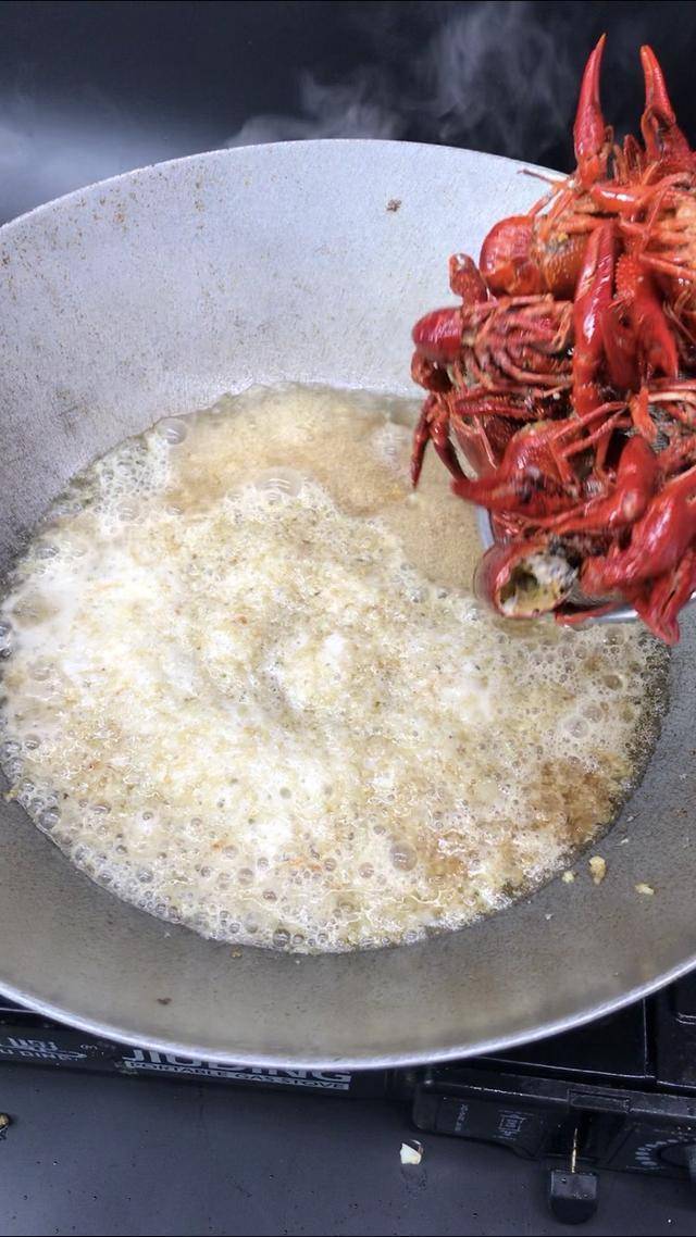 步骤八:下小龙虾翻炒,煮15分钟之后放葱花和白芝麻就可以出锅了.