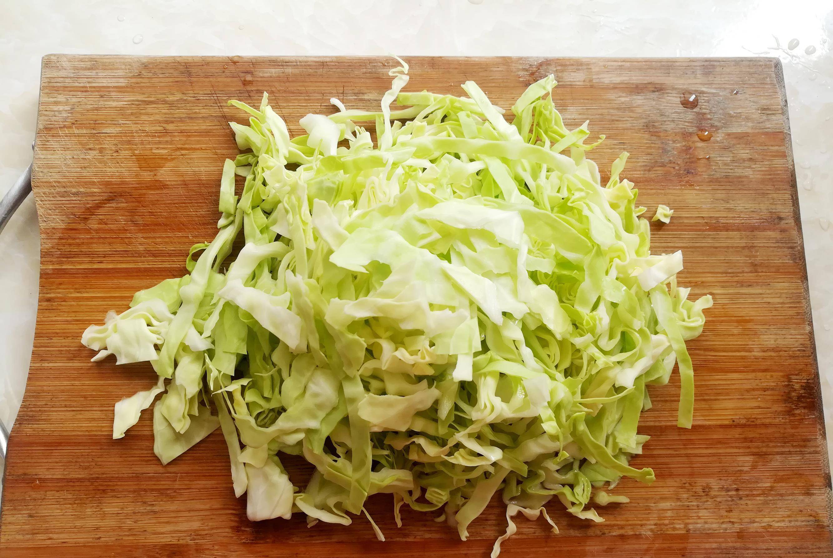 包菜叶子一张一张的剥开,清洗干净,叠起来切成细丝,切好后中间再任意