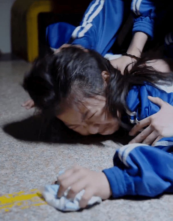 一群小学生,身穿校服,在学校楼道昏暗的灯光下,呈现了一场"真实"的