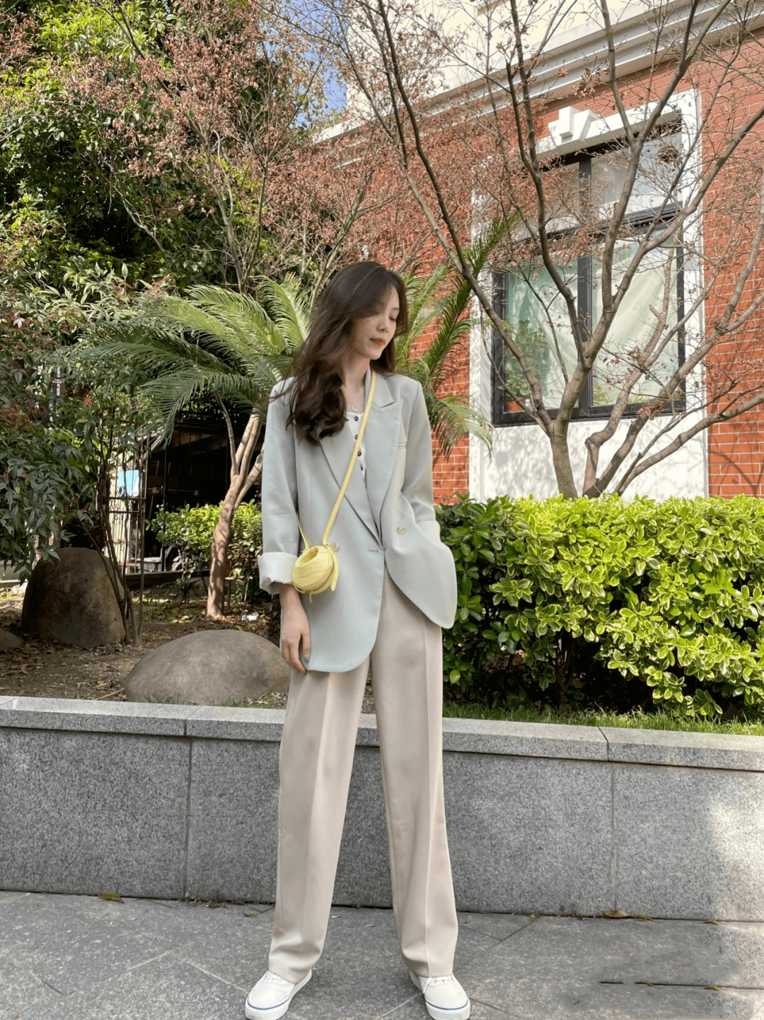 豆绿色西装外套搭配奶茶棕色西裤,再用一个明亮的黄色包包点缀,春日