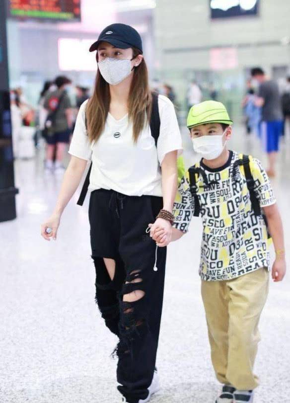 原创刘芸携子走机场裤子破的露大腿太招摇10岁儿子推行李很硬汉