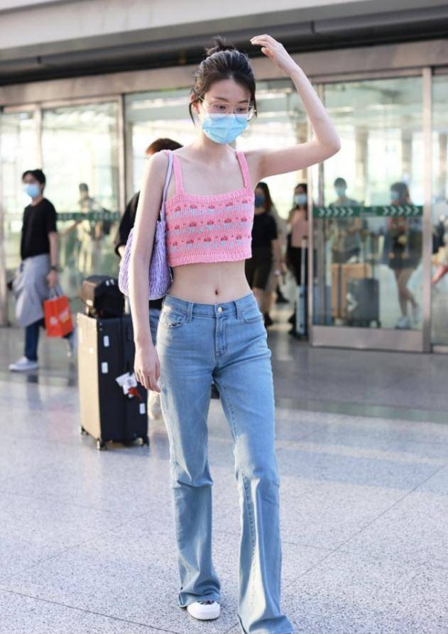 粉色吊带背心搭配蓝色牛仔裤,乔欣机场走秀,美出新境界!