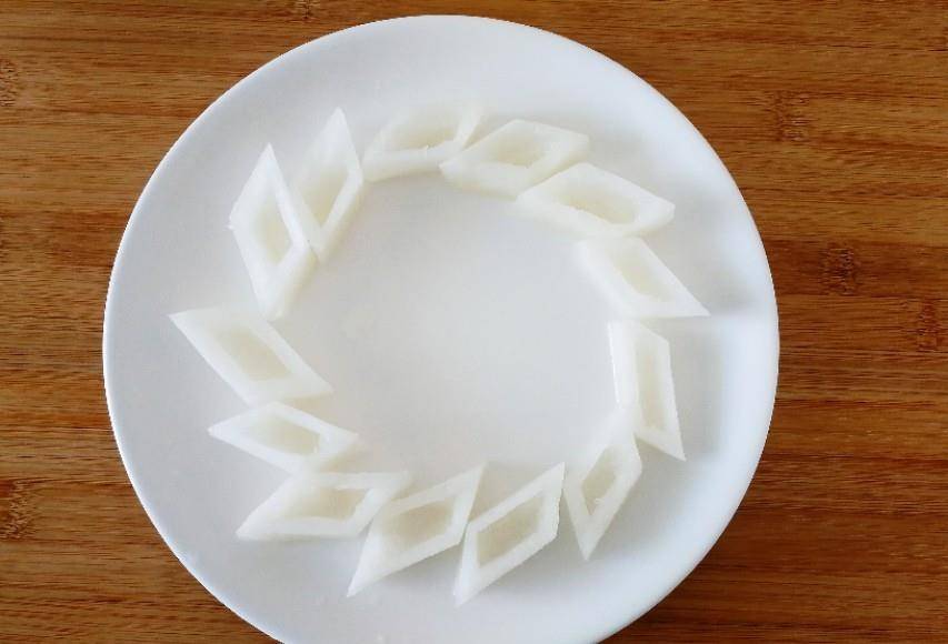 1.白萝卜一根 800克洗净去皮,切成菱形块,将中间挖空做成菱形容器.